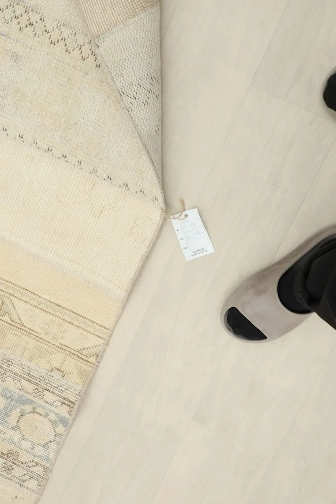 Underside of the rug revealing the hand-knotted cotton foundation and a product tag