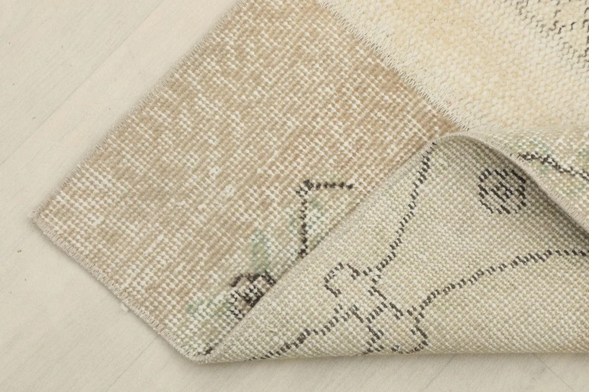 Corner of the rug folded to show the wool pile and cotton foundation