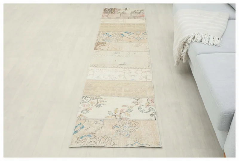 Full top view of the 1'11" x 8'6" beige floral patchwork runner rug on a white background.