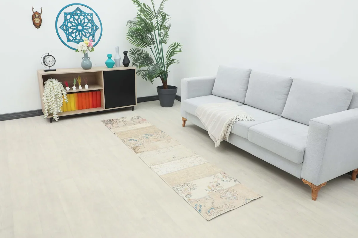 Runner rug displayed in a bright room setting next to a gray sofa and wooden cabinet.