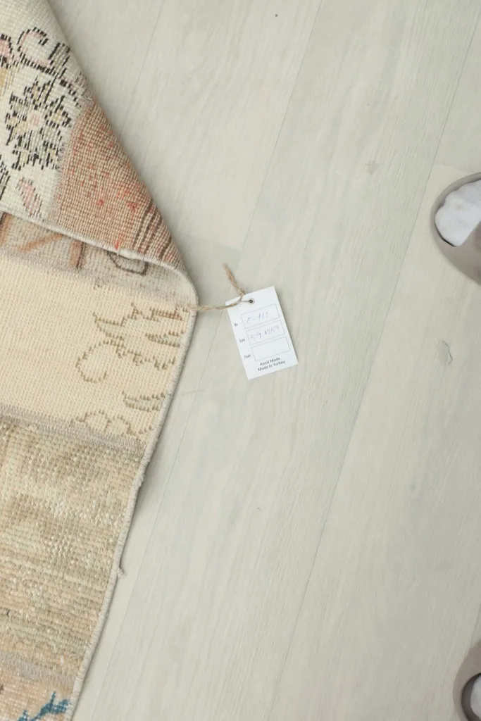 Close-up of a RugsKilim tag attached to the corner of the patchwork runner rug.