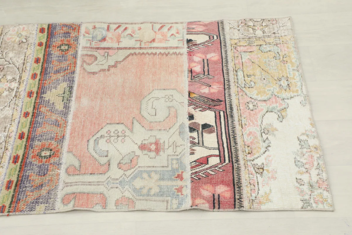 Close-up of the runner's patchwork sections, highlighting pink, blue, and yellow motifs
