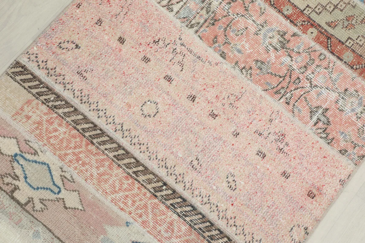 Angled close-up of the runner's texture and varied pink, beige, and gray patchwork sections