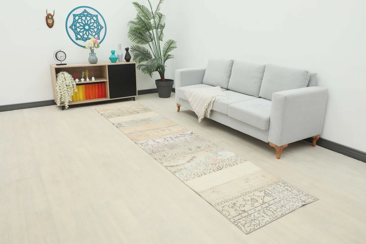 Vintage patchwork runner rug laid out in a modern living space with a light gray sofa