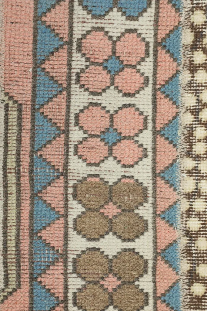 Macro detail of a pink and blue geometric pattern within a patchwork segment of the runner