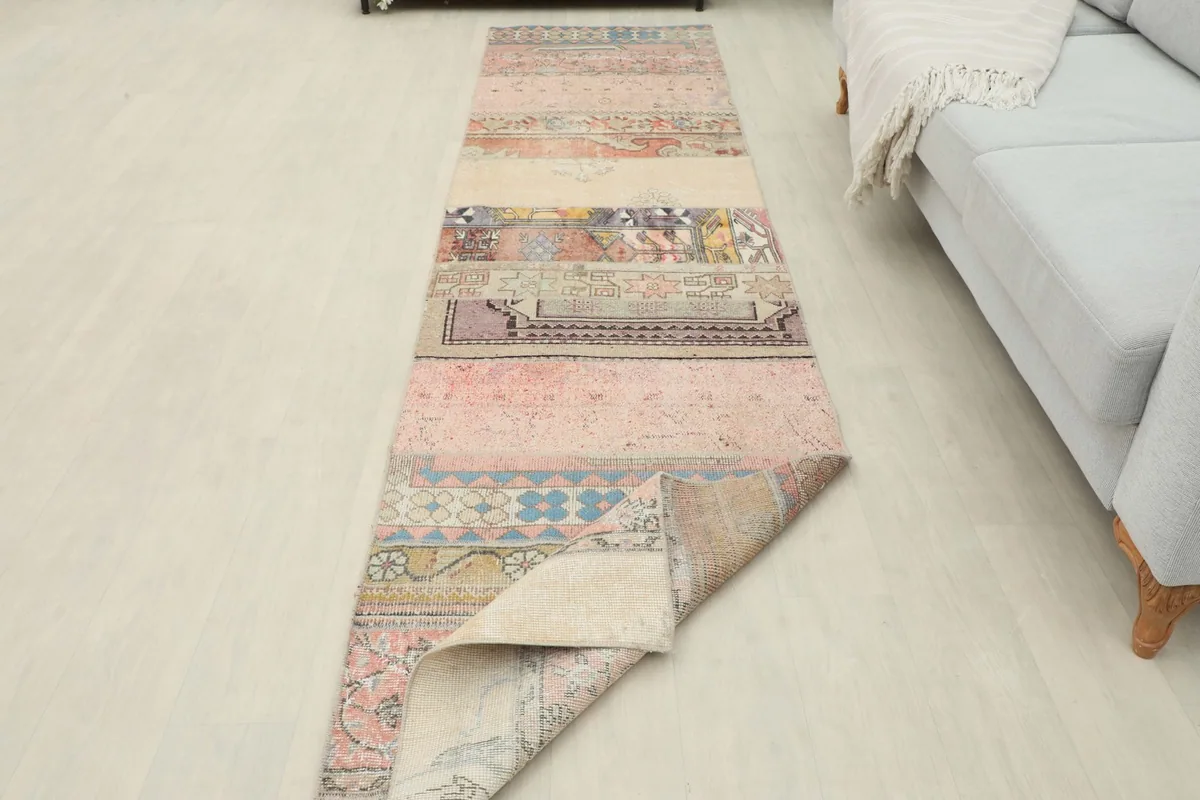 Runner rug with one end folded, showcasing the full length and the distinct patchwork sections in a room setting