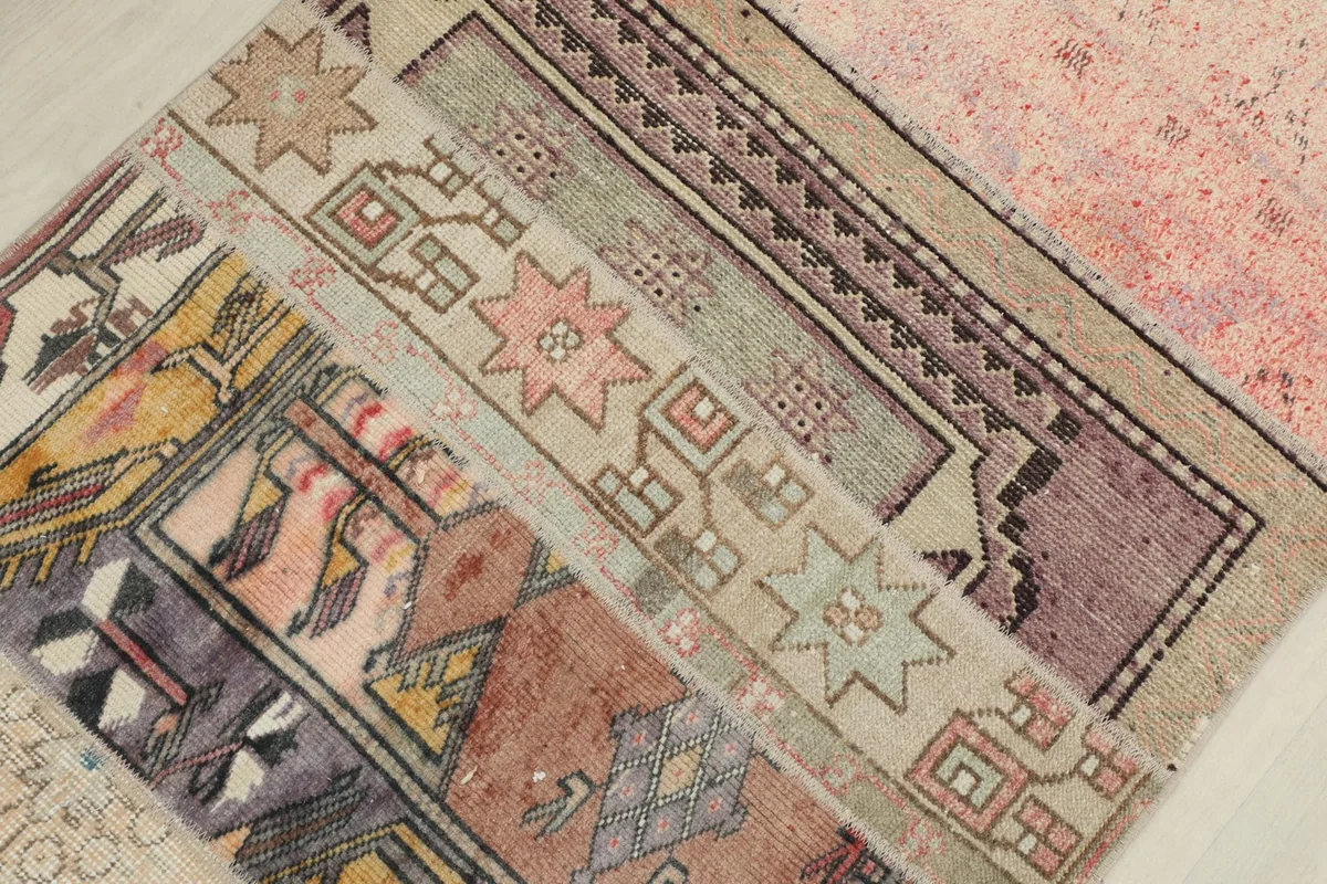 Overhead detail of the rug's central patchwork, revealing diverse tribal and geometric motifs in varied colors