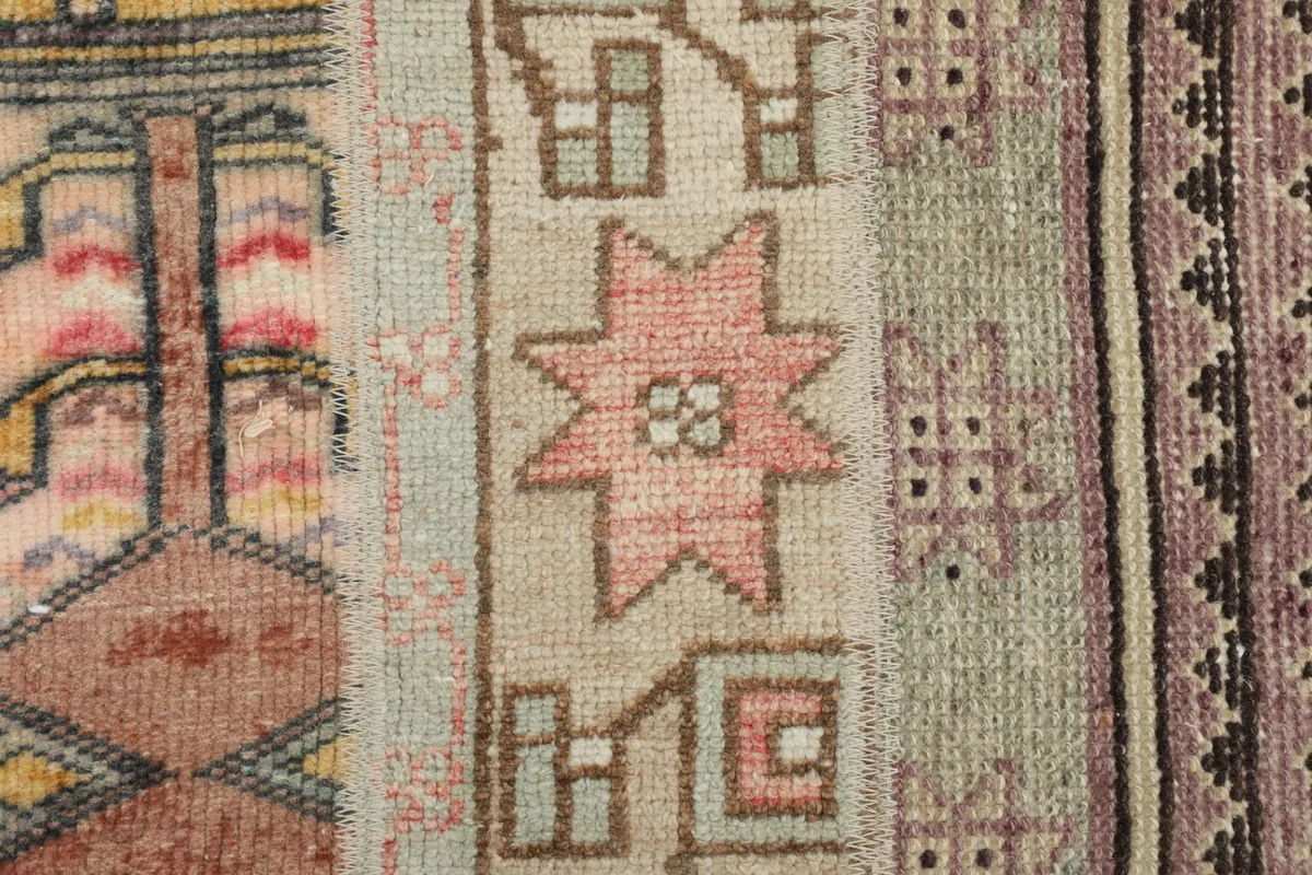 Close-up of hand-knotted wool pile, showing a rose star motif and intricate geometric designs within the patchwork