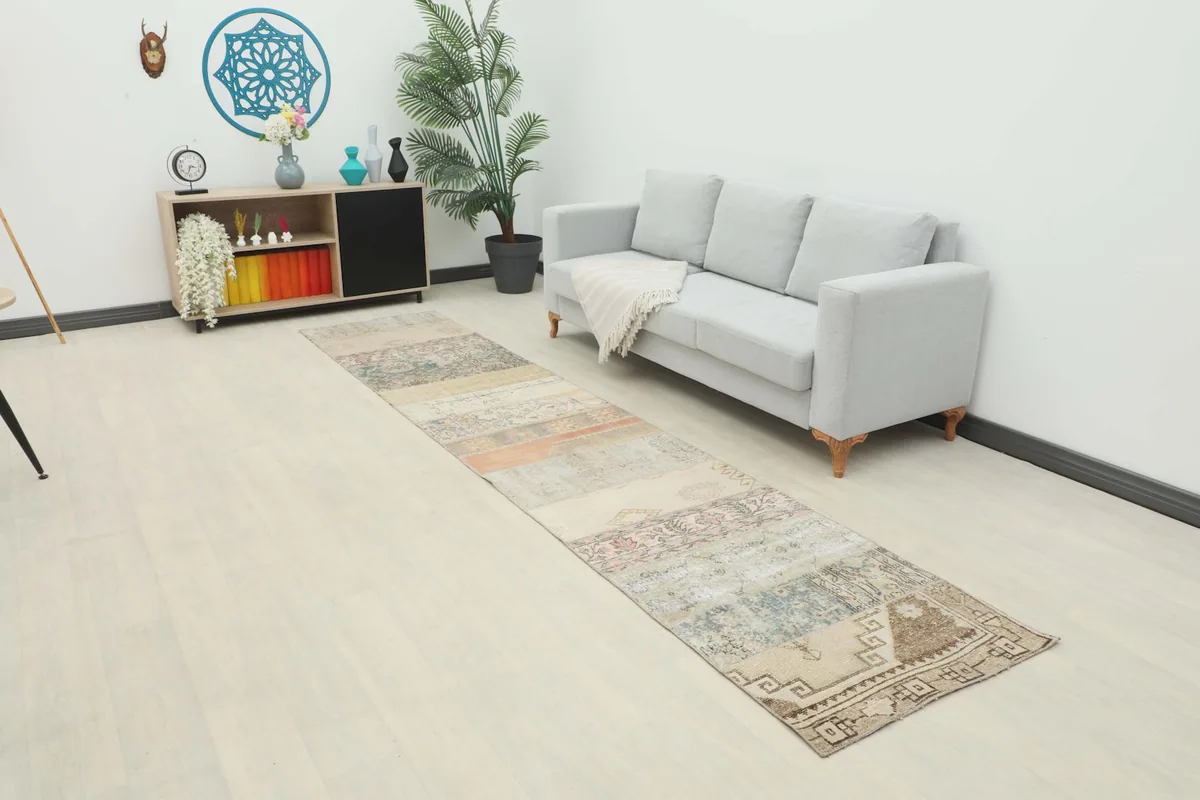Long runner rug laid out in a modern living space with a light gray sofa