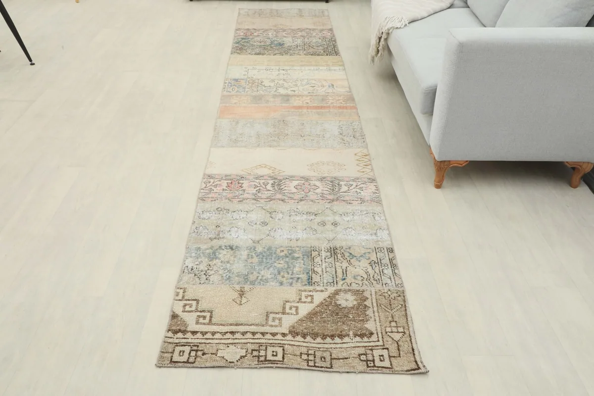 Full room view of the runner rug extending from the foreground towards a light gray sofa