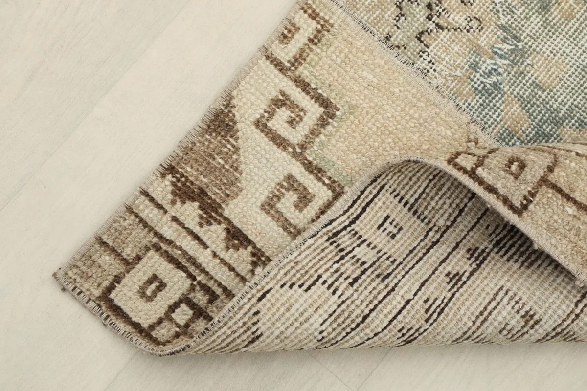 Underside and corner detail of the hand-knotted wool rug on a cotton foundation