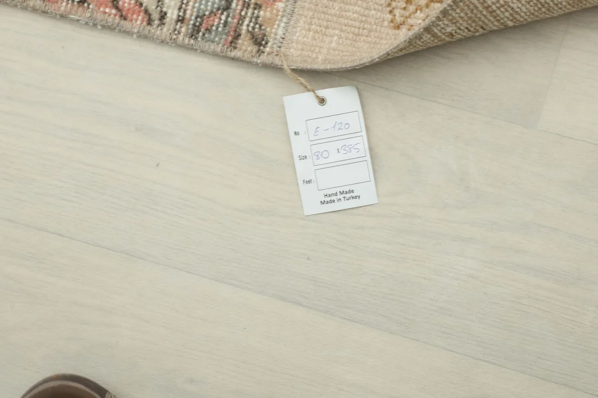 Product tag showing the rug's dimensions and origin, placed on the floor next to the rug