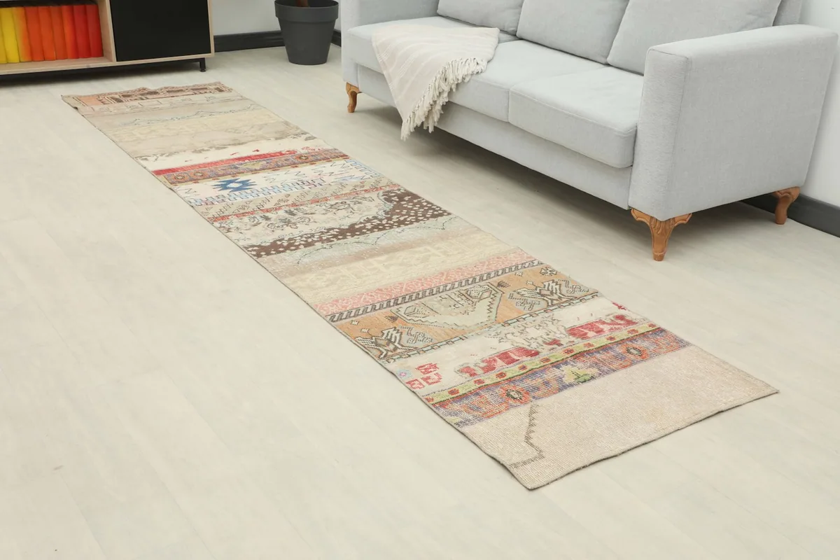 Angle view of the beige, red, and blue patchwork runner rug laid out in a contemporary space.