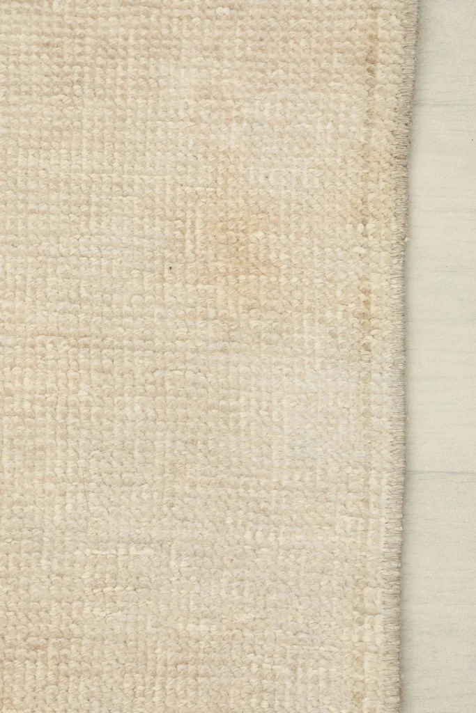 Underside view of the rug, showing the tightly woven cotton foundation and hand-knotted construction.