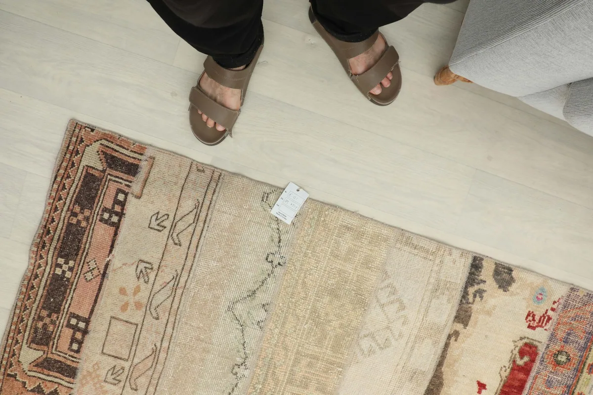 Overhead view showing a person's feet near the rug, providing a sense of scale and real-life appearance.
