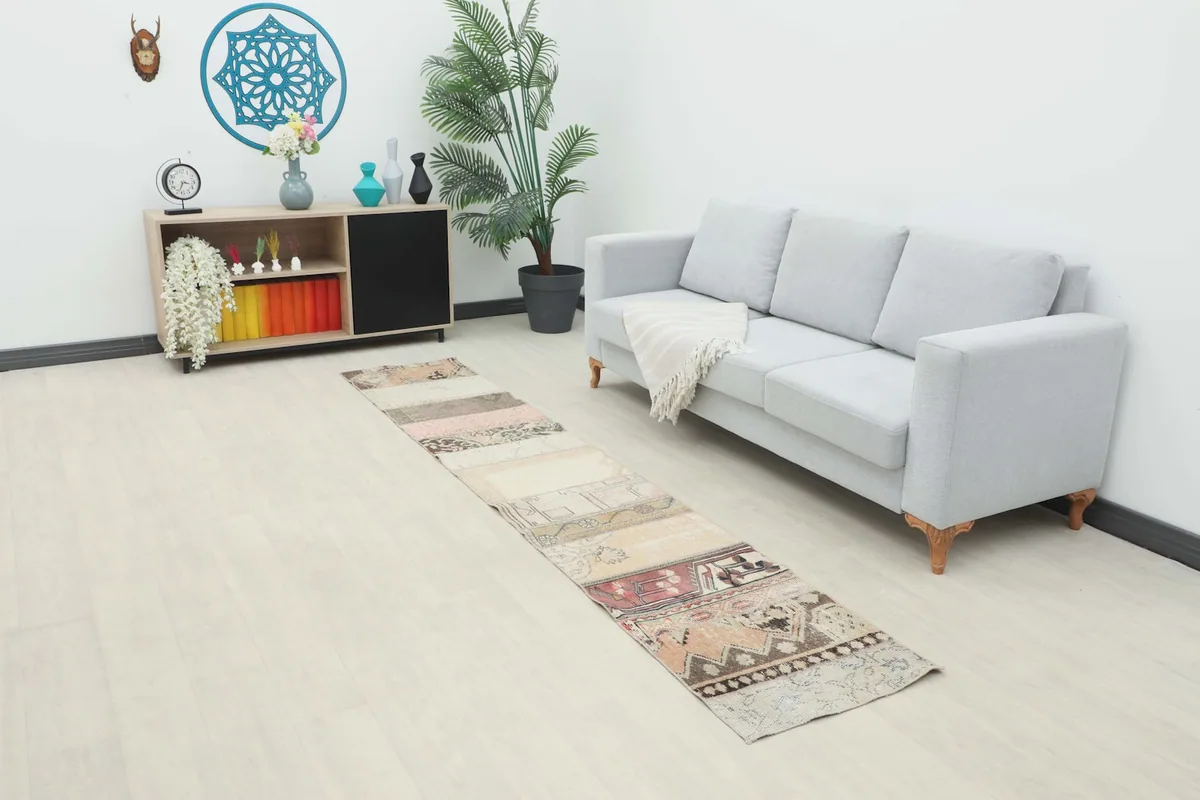 Vintage Anatolian patchwork runner rug in a modern living space next to a light gray sofa.