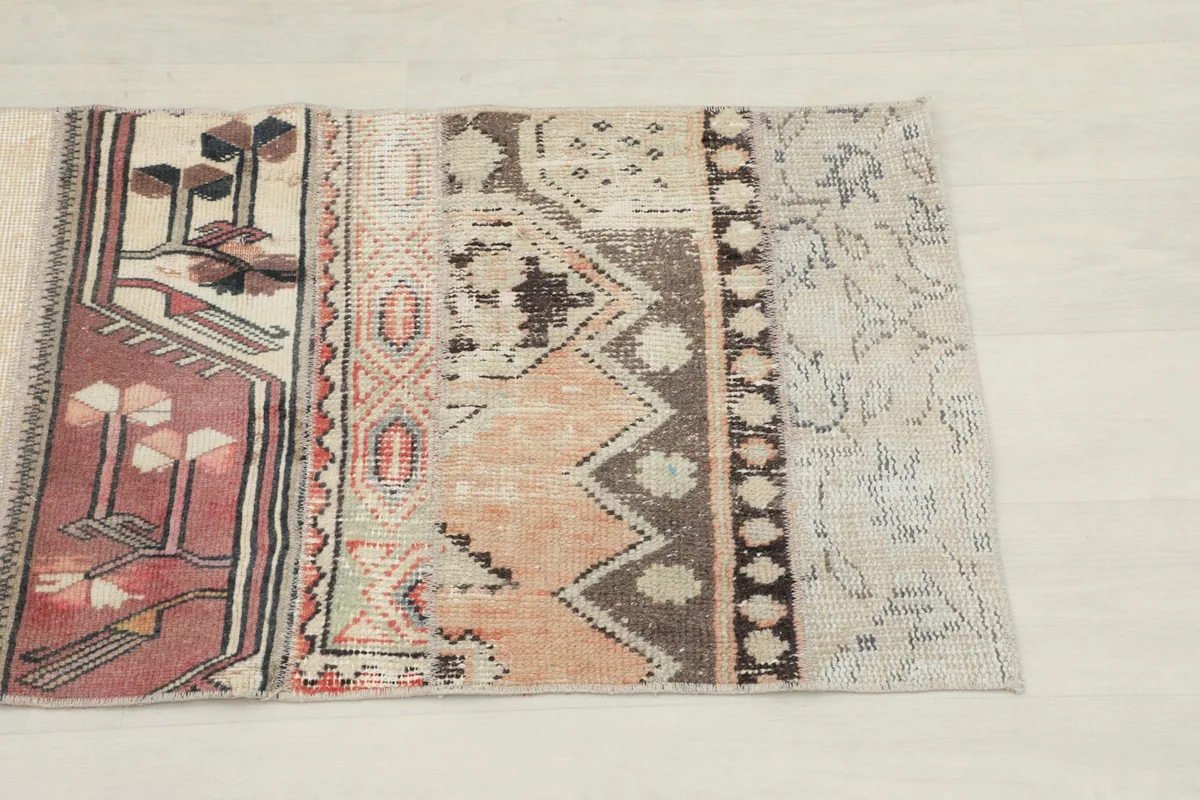 Close-up detail of a section of the patchwork runner showing rose, rust, and brown geometric patterns.