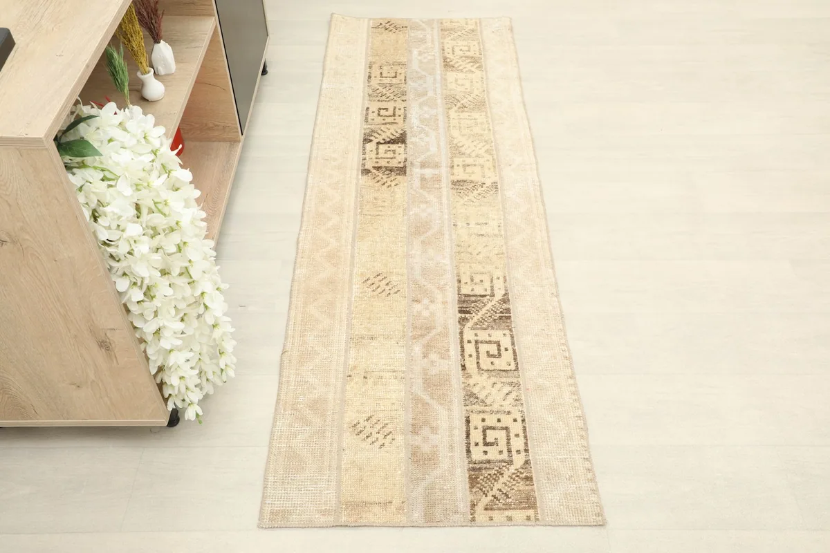 Overhead view of the tan runner rug, showing its full length and striped patterns.