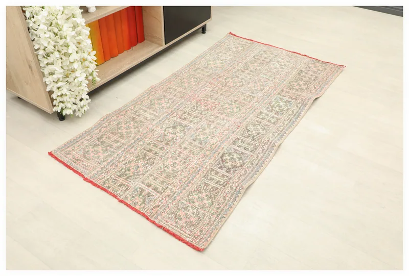 Full top view of the 2'9" x 5'1" vintage Anatolian rug with geometric patterns in rose, olive, and blue.
