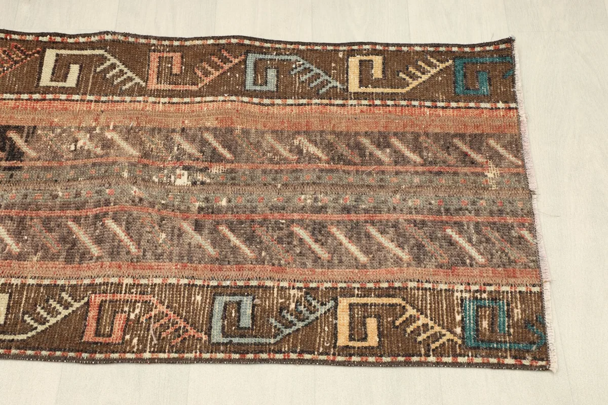 Angled view showing the upper right section of the rug, including blue and orange accents.