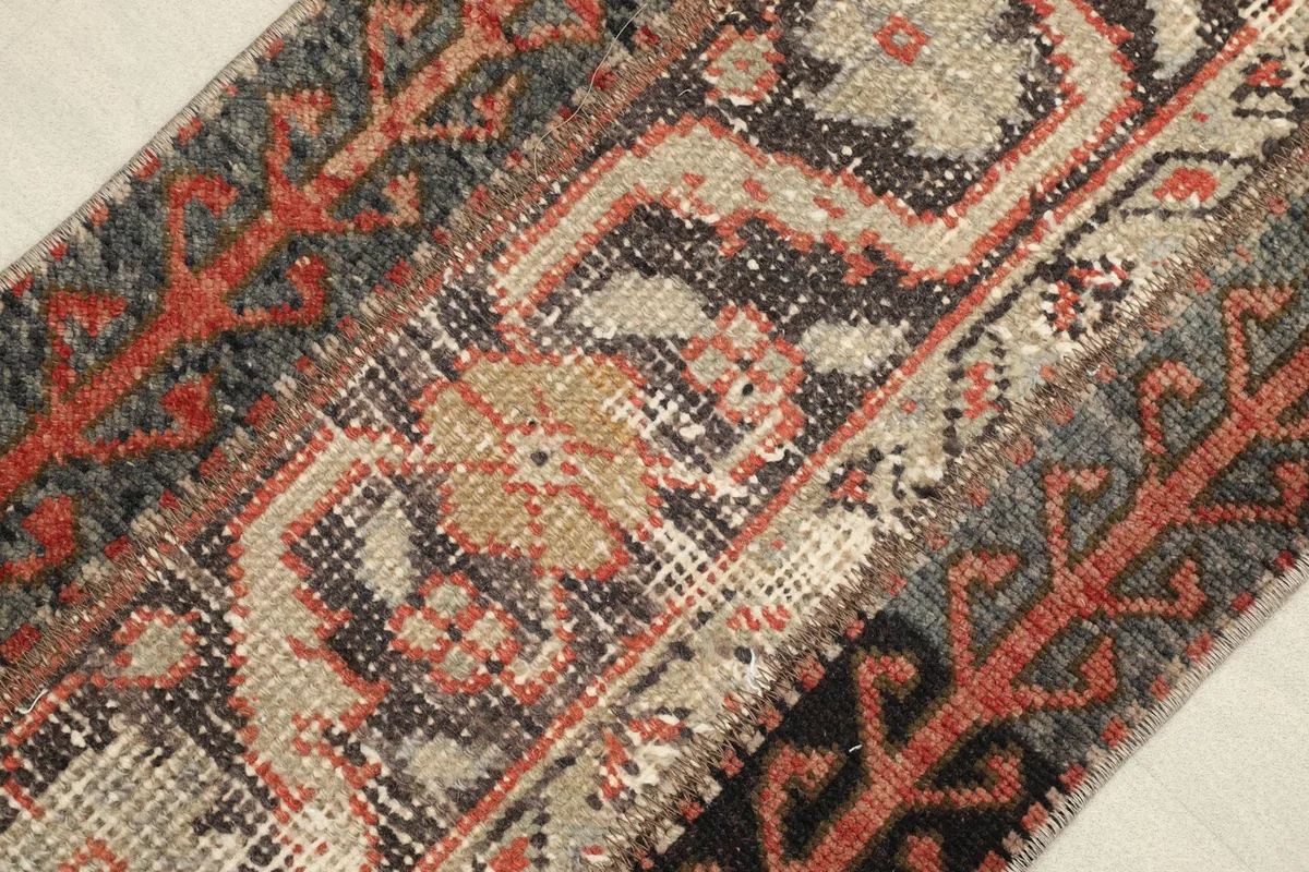Detailed close-up showing the hand-knotted wool pile, individual knots, and areas of natural wear.