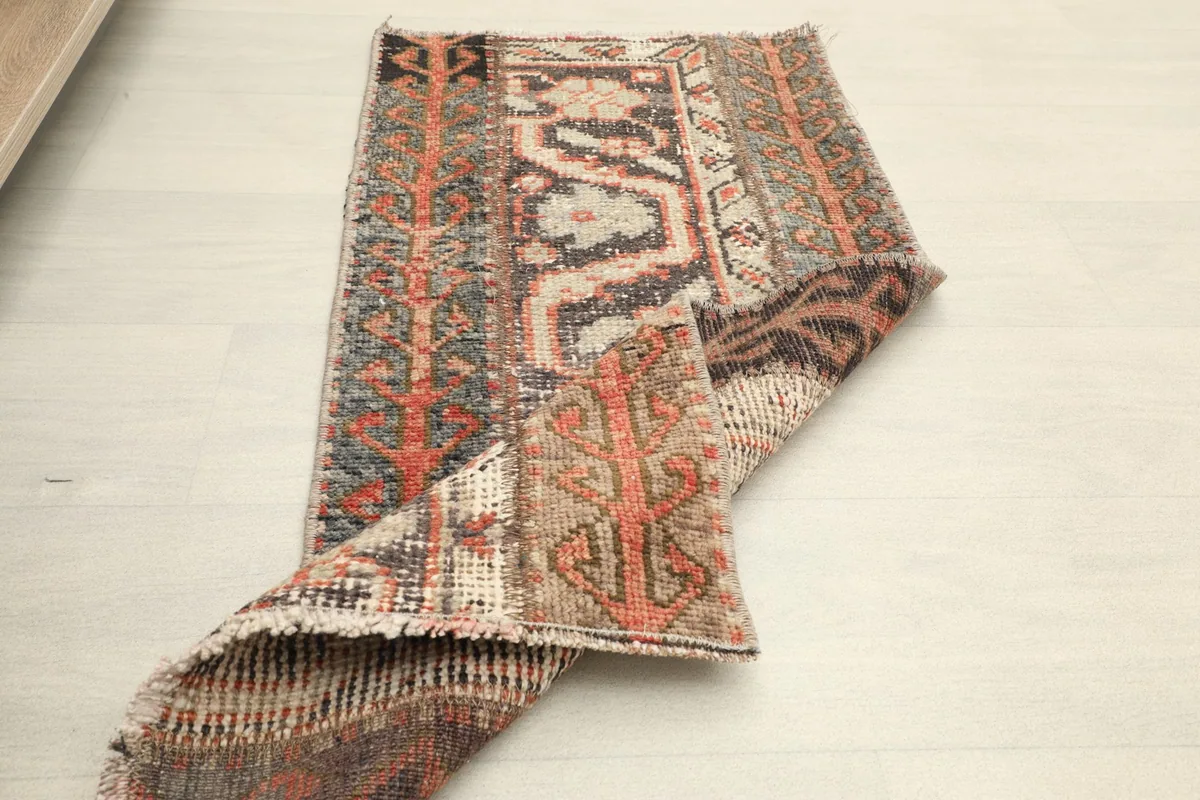 The rug partially folded, displaying both the top surface with its patterns and the reverse side.