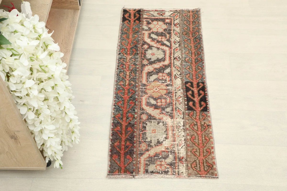 Overhead view showcasing the full length and distinct patchwork sections of the small vintage rug.