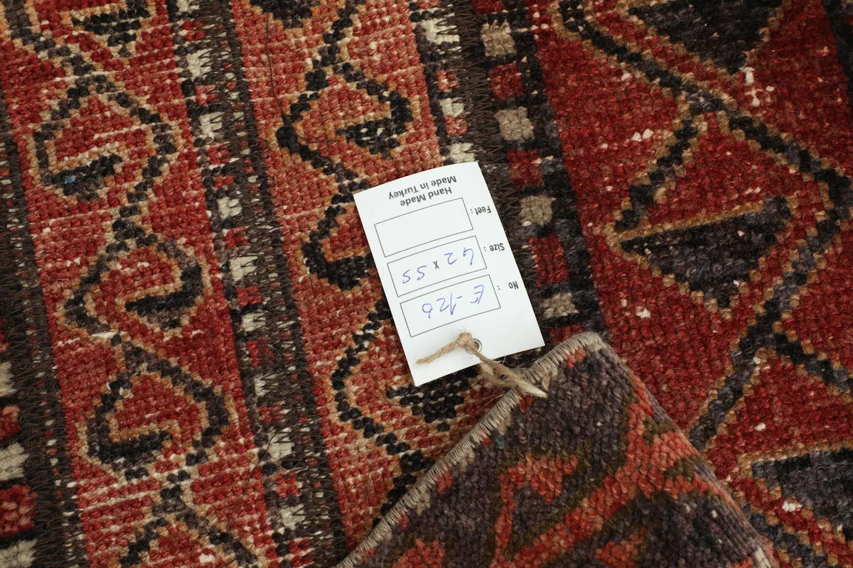 Close-up of the rug's reverse side, showing the hand-knotted construction and a product tag.