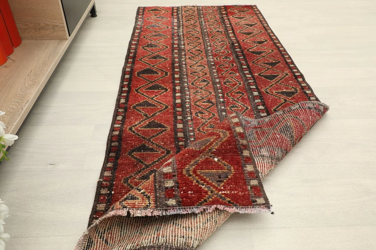 View of the rug partially folded, showing the pile and the back construction.