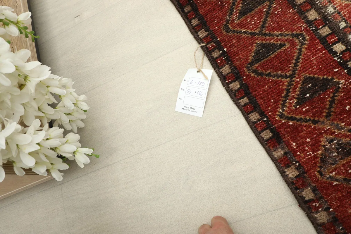 Corner of the rug with a tag, providing a sense of scale and authenticity.