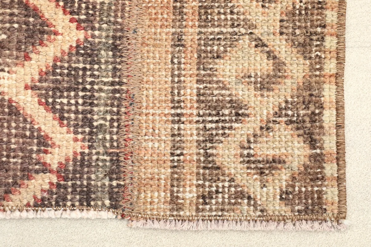 Close-up view of the rug's border and fringe, showing the hand-knotted wool texture.