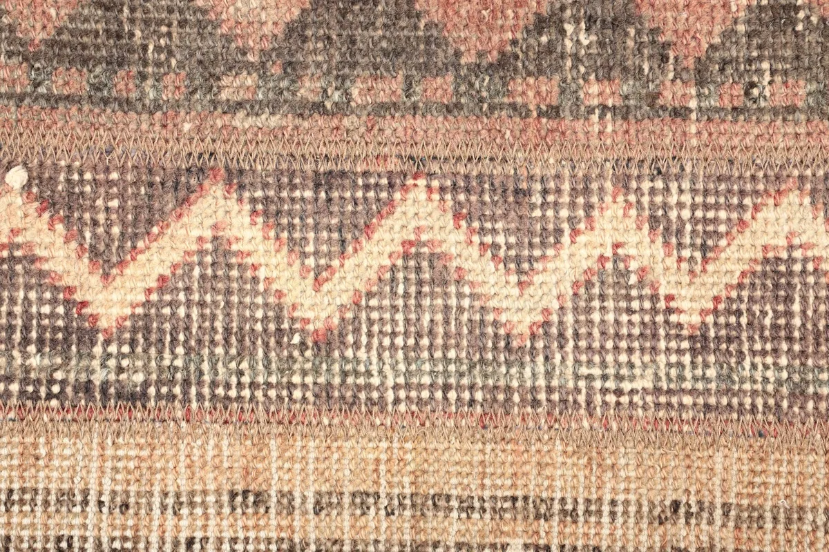 Detailed shot of the low wool pile, showing the intricate knotting and color variations.