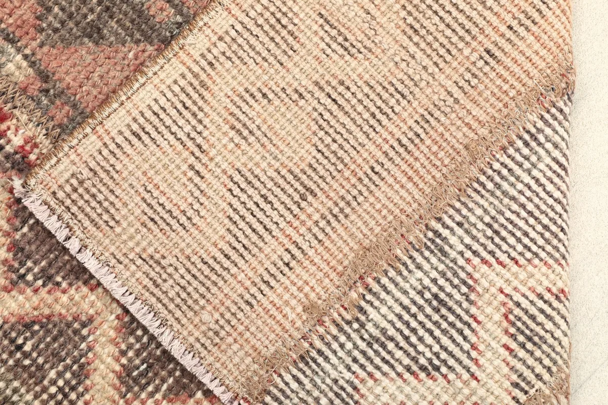 Close-up of the rug's cotton foundation and the back of the hand-knotted wool pile.