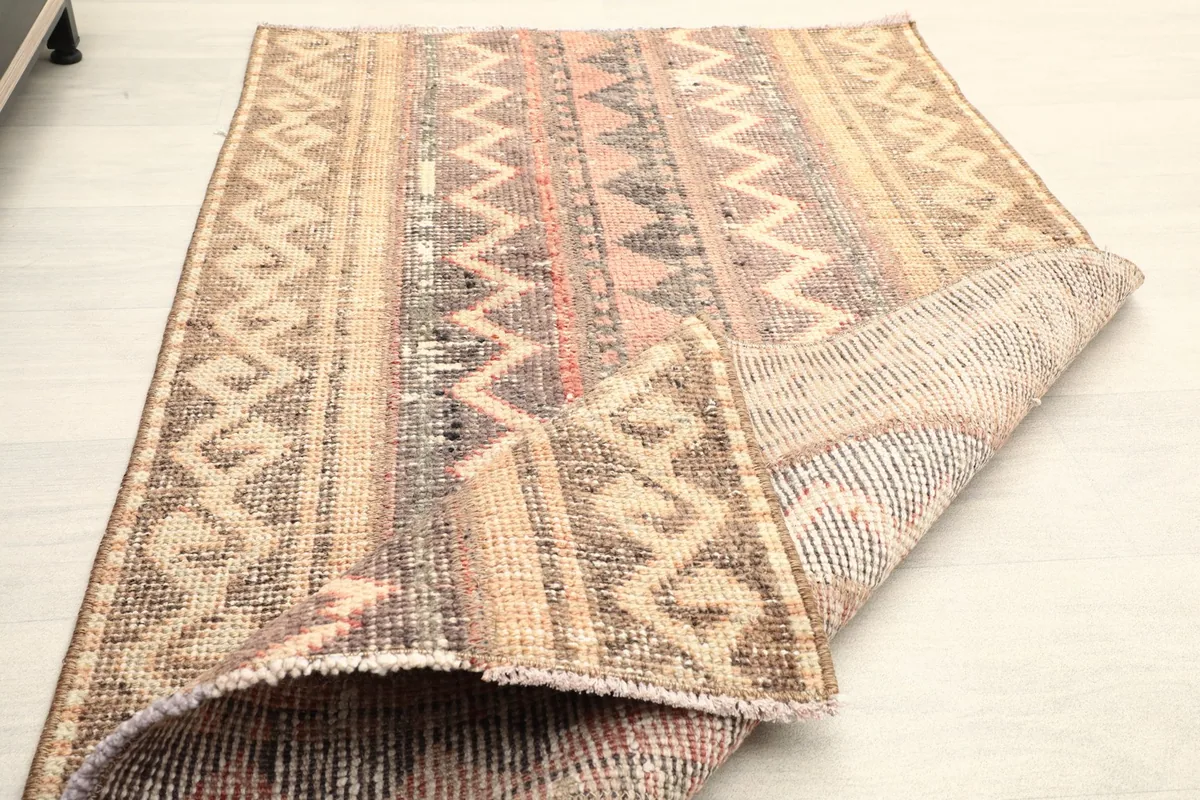 The rug folded back to show the thickness and flexibility of the vintage textile.