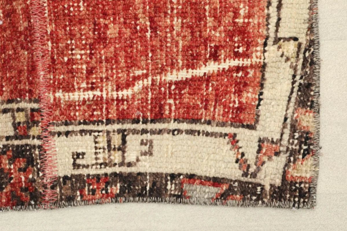 Close-up view of the rug's corner, showing the border design and visible wear.