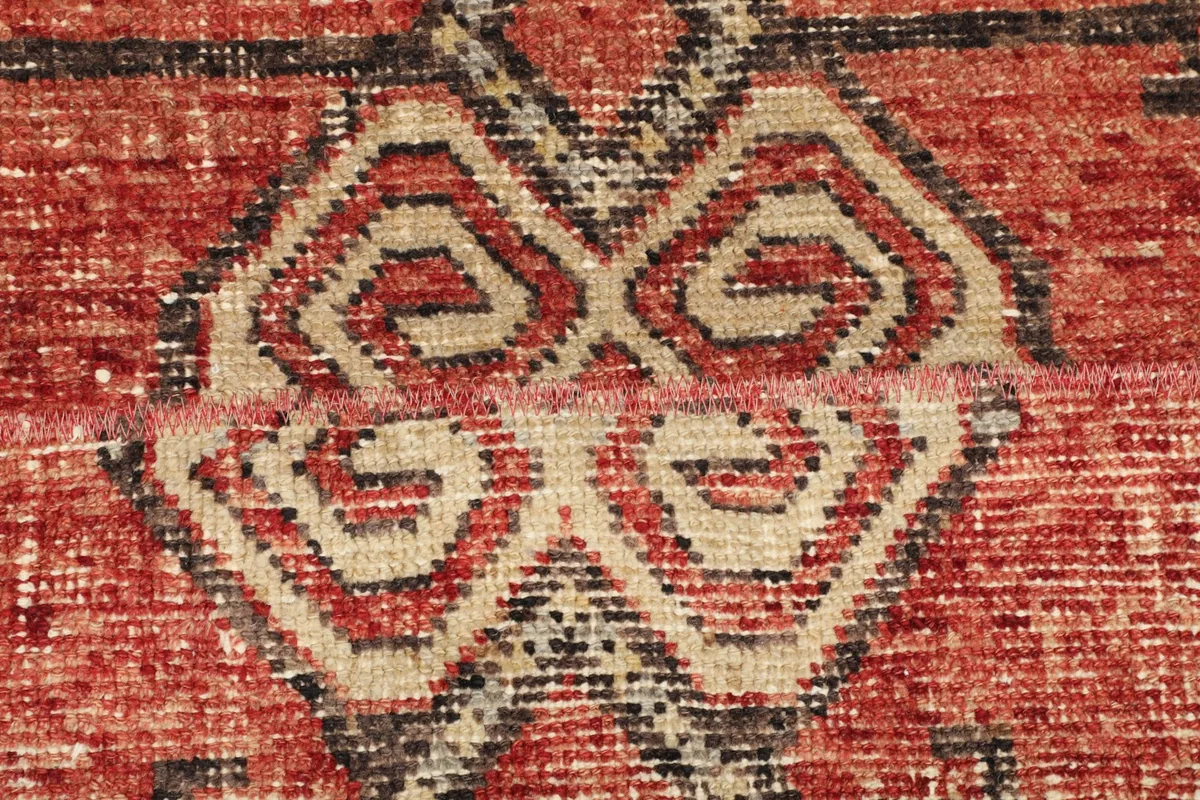 Detailed shot of the central geometric motif, showcasing the knotting and color variation.