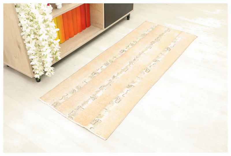 Full top view of a beige and rust vintage Anatolian runner rug with geometric stripes