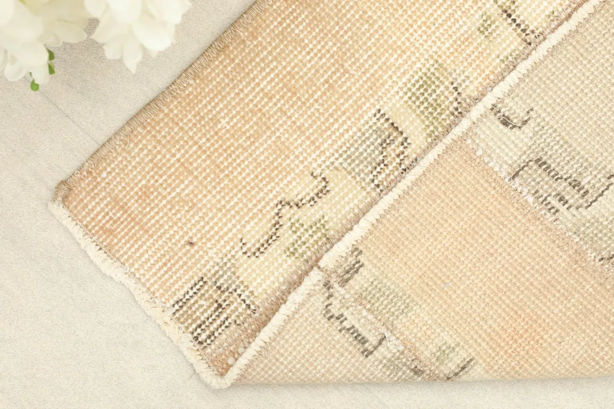 Corner of the rug folded back to reveal the cotton foundation and reverse side of the knots
