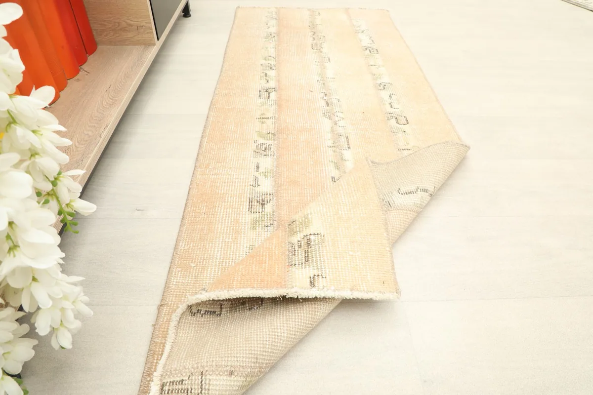 Rug partially folded, displaying the texture and flexibility of the vintage wool material