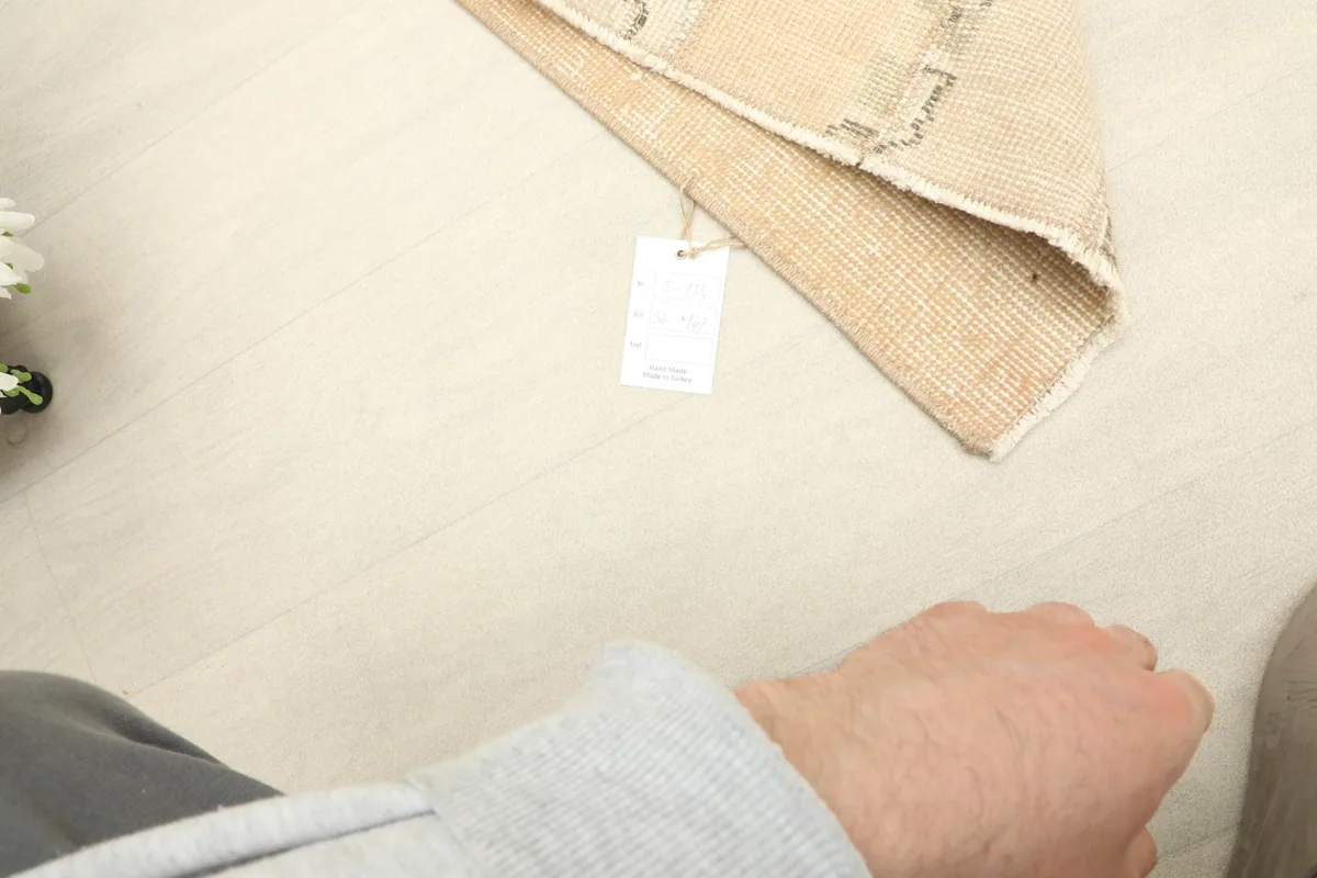 Hand next to the rug to provide a sense of scale and the rug's low pile