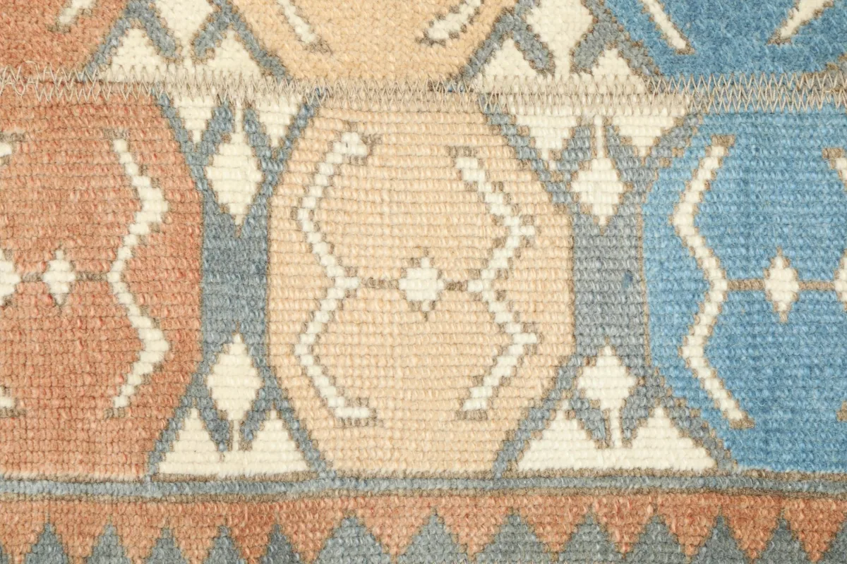 Close-up detail of a tan geometric motif within the field of the Anatolian rug