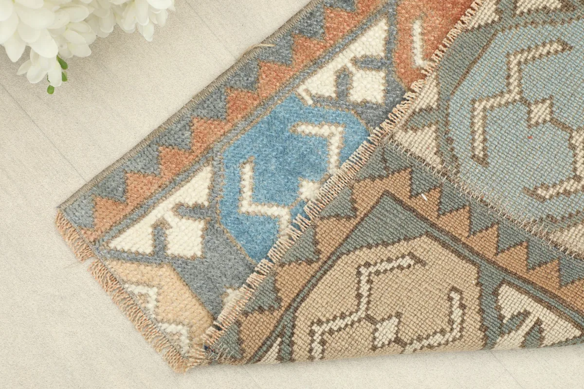 Corner of the Anatolian rug folded to show the wool pile and cotton foundation