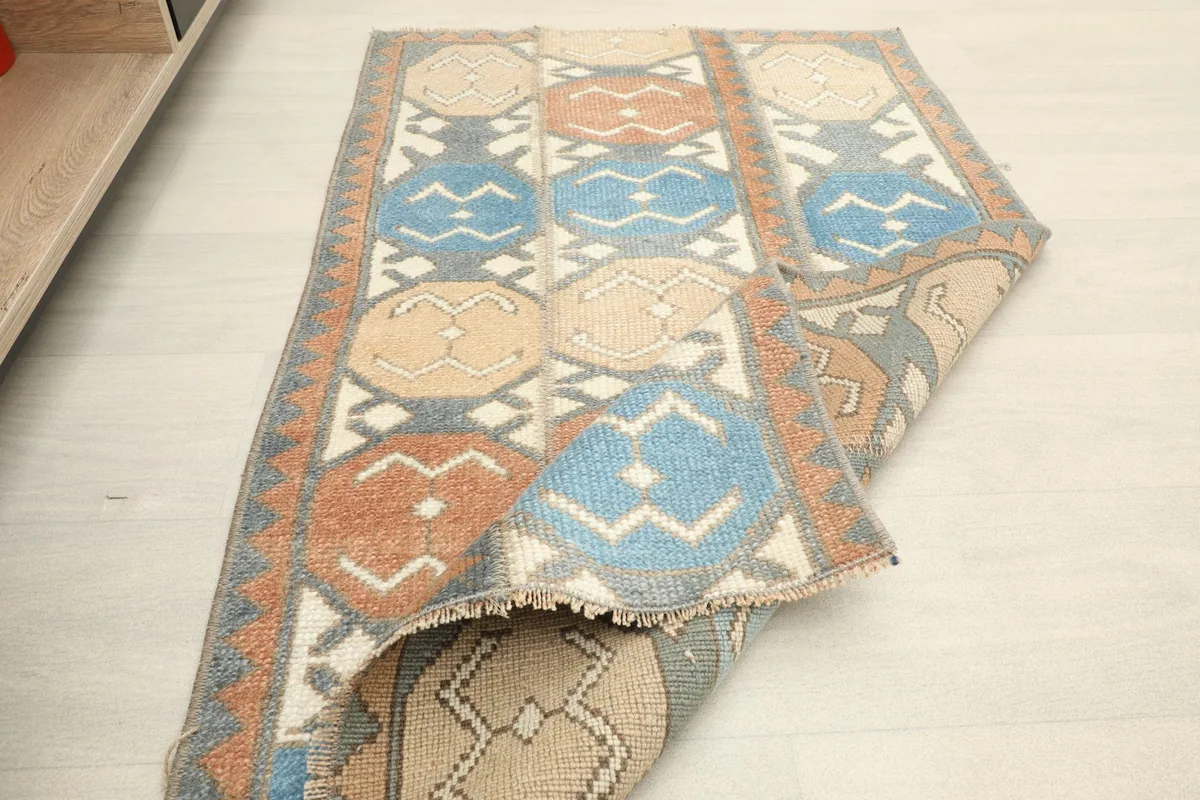 The vintage rug partially folded, displaying its flexibility and construction
