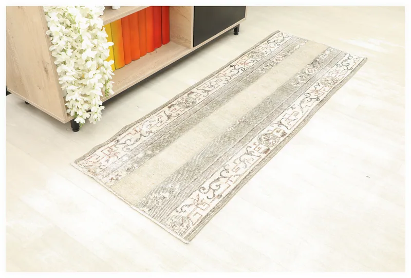 Full overhead view of the beige and gray striped vintage Anatolian runner rug on a white background.
