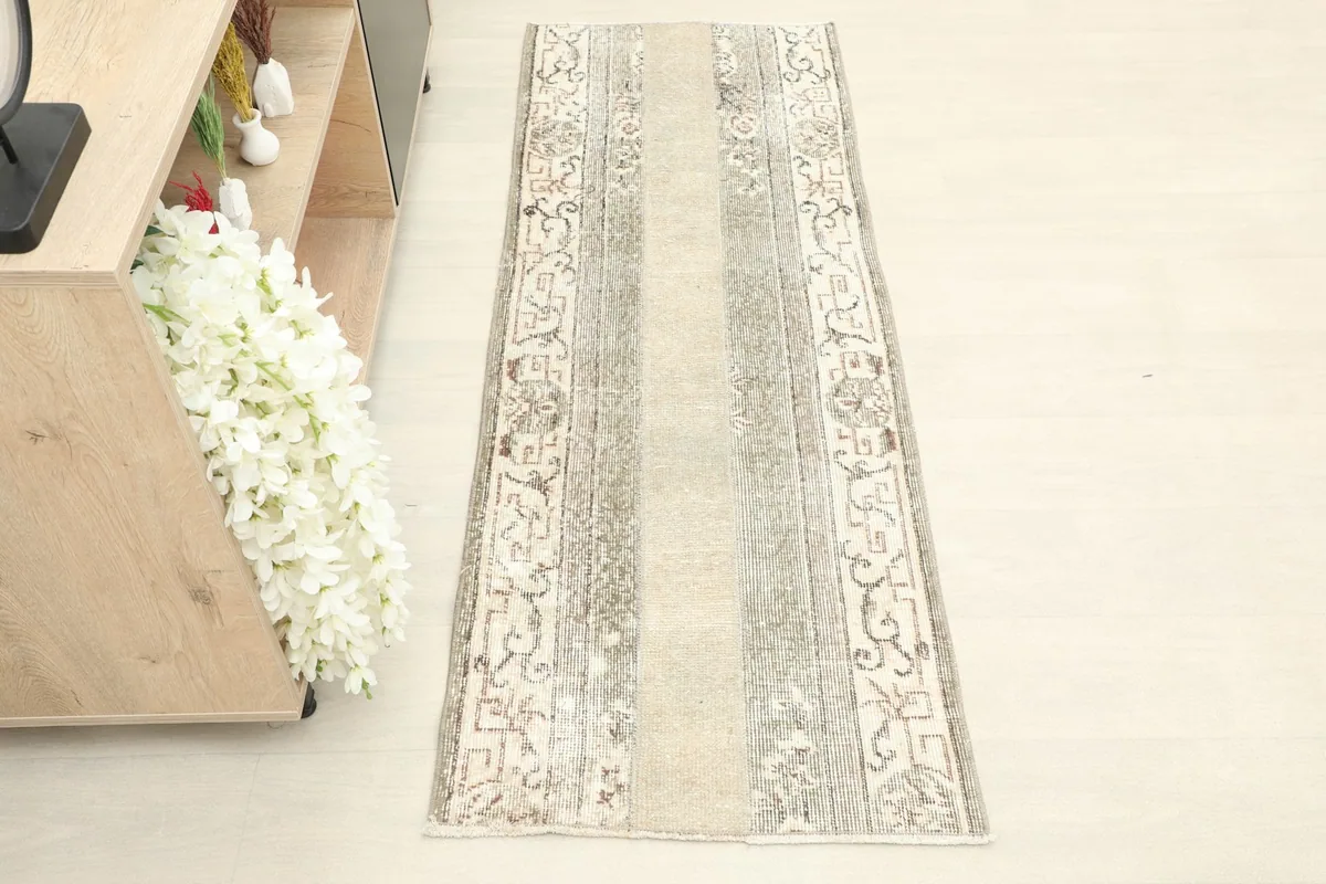 Top-down view of the runner rug placed in a room setting next to a light wood shelf with books.