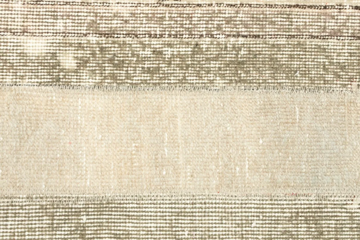 Extreme close-up of the low wool pile and the intricate hand-knotted details of the rug's surface.