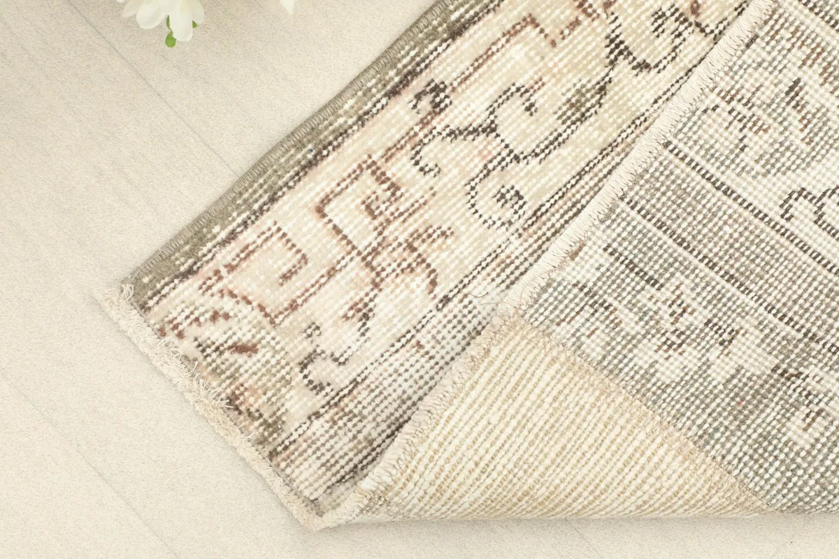 View of the back of the rug, revealing the cotton foundation and the hand-knotted construction.