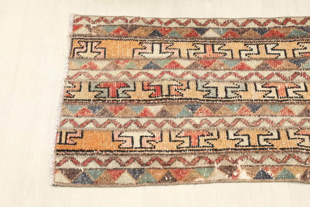 Angled view of one end of the runner, emphasizing the alternating striped patterns.