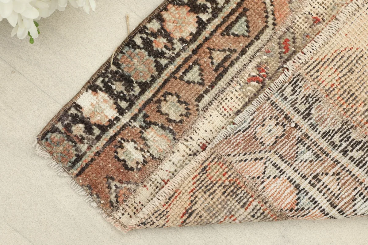 Corner of the rug folded back, revealing the wool pile and cotton foundation