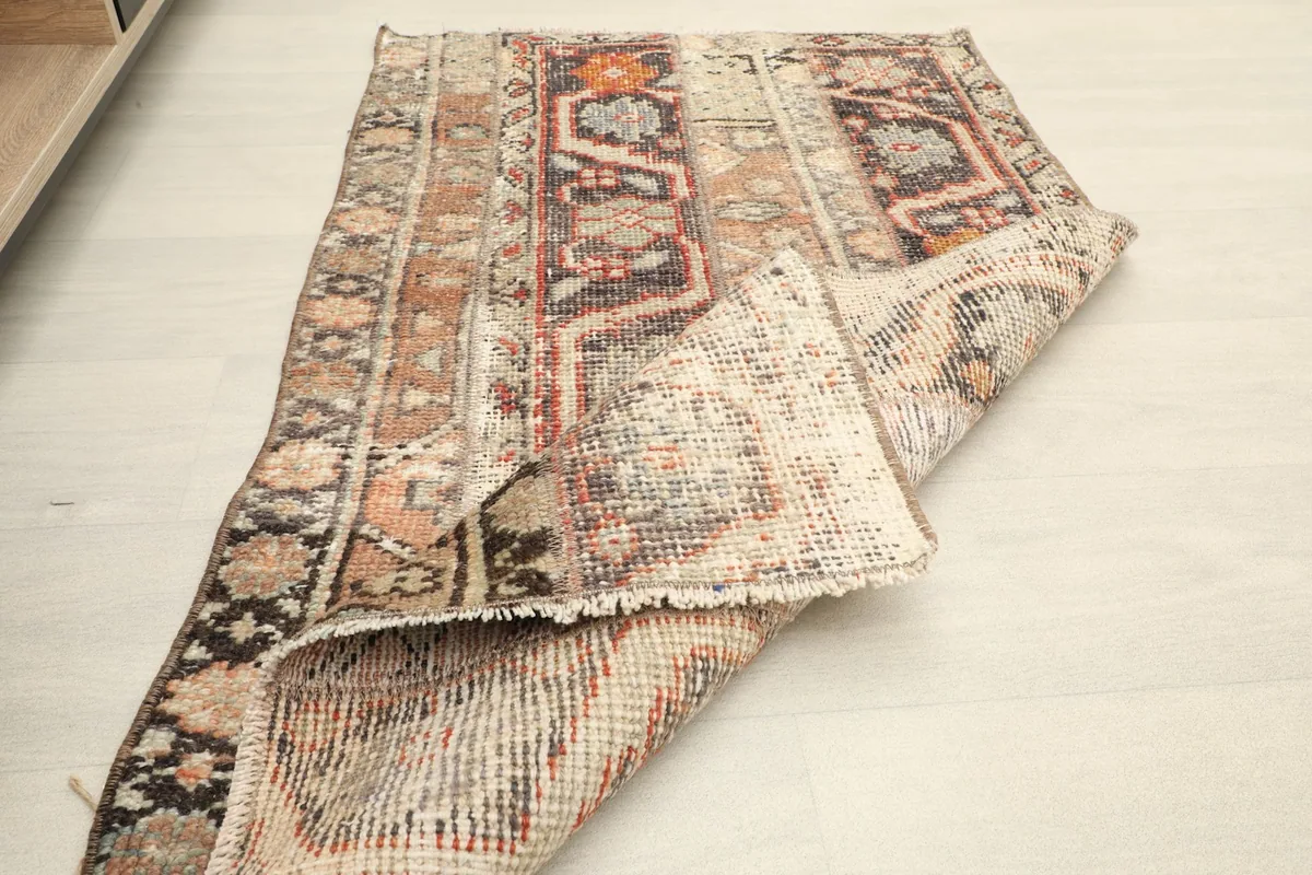 Rug partially folded, showing the reverse side and construction details